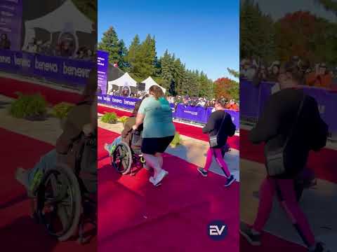 People crossing the pink Montréal marathon finish area together, including a participant in a wheelchair